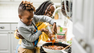 Mom and son are seen together cooking